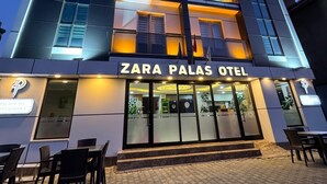 Un hotel de varios pisos con el restaurante Zara Palas en la planta baja.