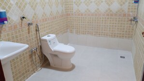 Un baño con inodoro, lavabo y ducha.