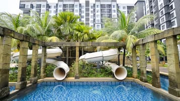Una piscina al aire libre, sillones reclinables de piscina