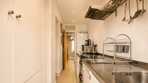 Una cucina moderna con elettrodomestici in acciaio inossidabile, forno integrato e lavello.
