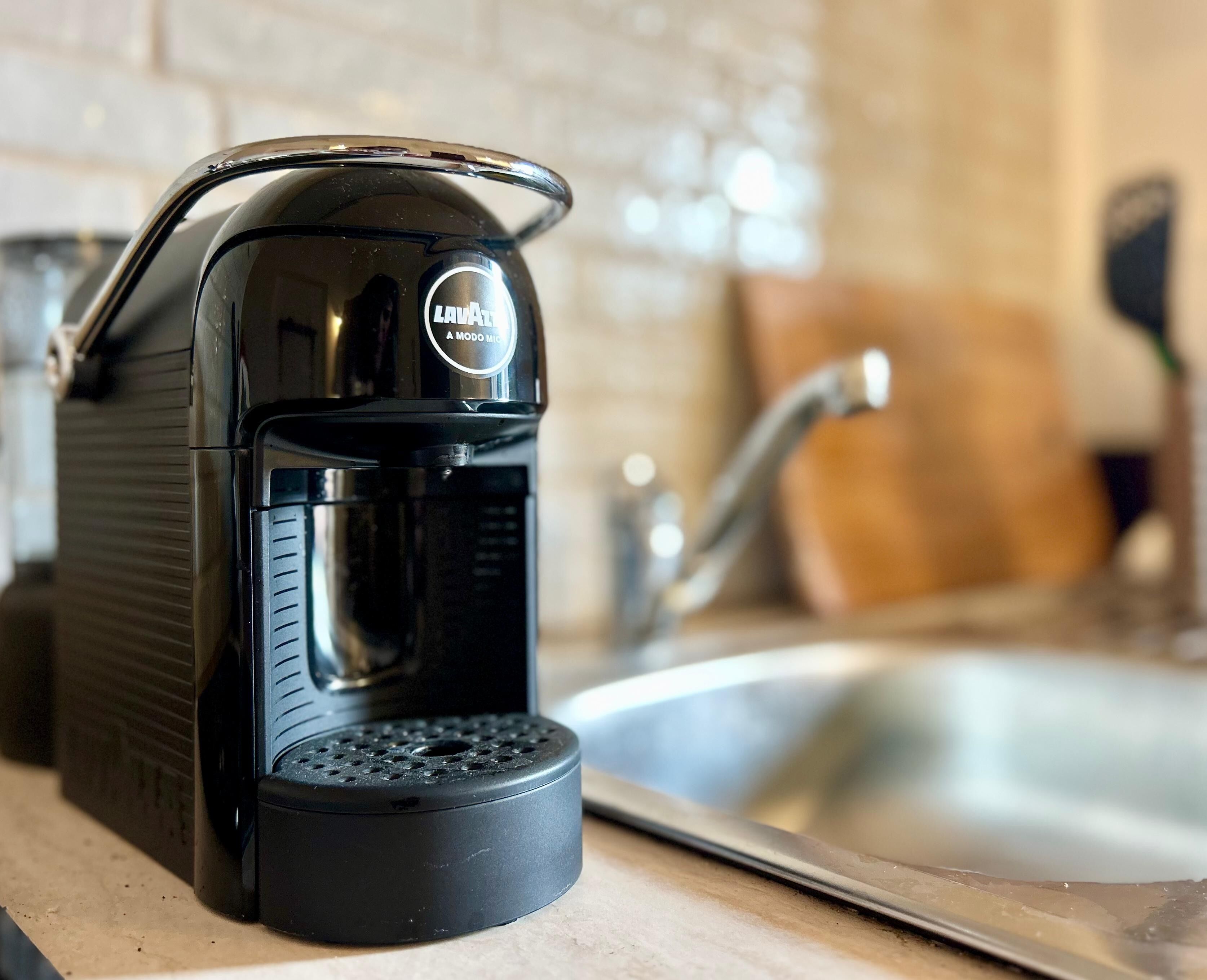 A coffee maker with a drip tray on a kitchen counter.