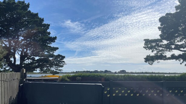 Ein Whirlpool mit Seeblick und Bäumen, umzäunter Bereich und eine Bank.