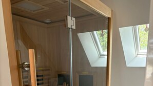 Ein modernes Zimmer mit Glastür, Holzrahmen und Oberlicht.