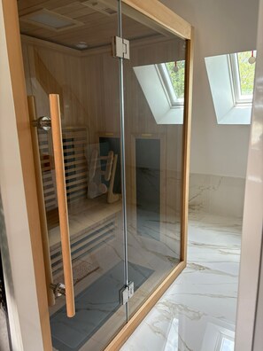 Ein modernes Zimmer mit Glastür, Holzrahmen und Oberlicht.