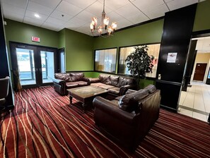 A lobby with a red carpet, leather couches, a chandelier, and an exit sign. - Cozy 1-bedroom bed & breakfast in wonderful Albany with AC (Albany)