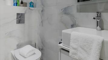 A modern bathroom with a toilet, bidet, and sink.