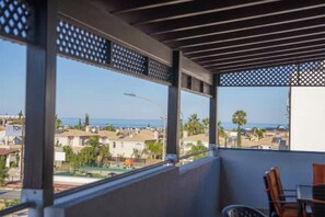 Un balcon donnant sur un quartier résidentiel et l’océan.