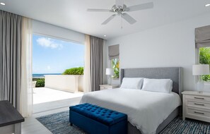 Ein Schlafzimmer mit einem großen Bett, einem Deckenventilator, Meerblick und einem Balkon.