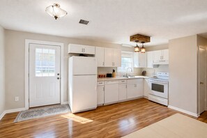 A kitchen with white cabinets, a refrigerator, a dishwasher, a stove, and a sink. - Cozy home with fenced yard (Bowling Green)