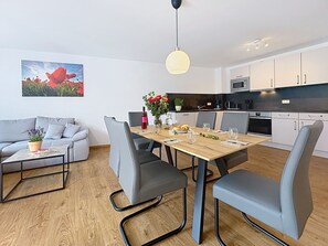 A modern living space with a dining area, kitchen, and a sofa set. - Cosy apartment for 5 guests with WIFI, TV and balcony (Endingen)