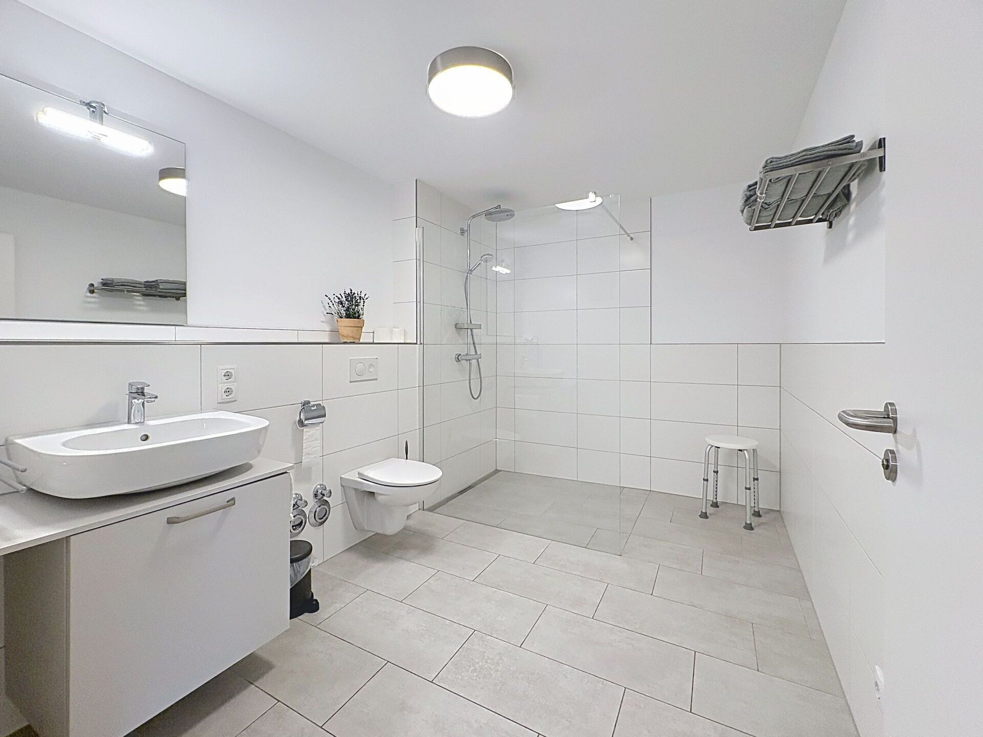 Une salle de bain moderne équipée d’un lavabo, de toilettes et d’une douche.