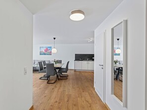 Eine moderne Küche mit weißen Schränken, einer schwarzen Arbeitsplatte und einem eingebauten Backofen.