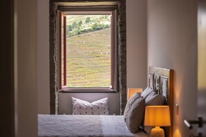 A bedroom with a view of terraced fields through a window. - Feel Discovery Casa Fonte do Lagar (Desejosa)