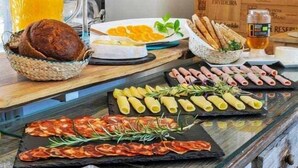 Ein reichhaltiges Frühstücksbuffet mit verschiedenen Speisen und einer Kerze auf dem Tisch.