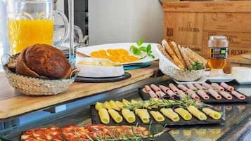 Un bufé de desayuno con distintos alimentos y una vela sobre la mesa.