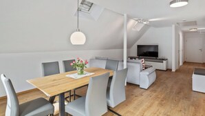 A modern living space with a dining area, seating, a TV, and a staircase. - Lovely apartment for 5 guests with WIFI and TV (Endingen)