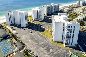 Un grand hôtel à plusieurs étages, doté d’un parking et offrant une vue sur la plage.