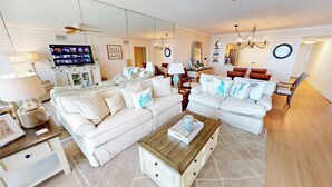 Ein Wohnzimmer mit Sofa, Couchtisch, Fernseher und Essbereich.