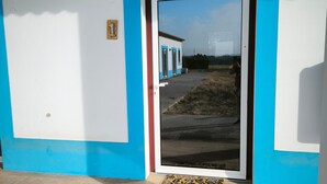 Eine Tür mit Fenster, eine Wand in Blau und Weiß und ein gefliestes Eingangsbereich.