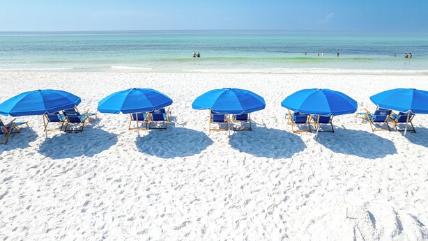 A beach with five blue umbrellas and beach chairs aligned in a row. - Stunning GulfView Islander Beach Resort 405 (Fort Walton Beach)