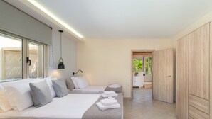 Ein modernes Hotelzimmer mit zwei Betten, einem Kleiderschrank und Blick ins Freie.