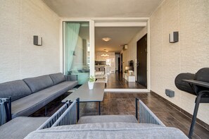 A modern living area with a sofa, a table, and a view into the kitchen. - St. Julian's Apartment 501 - Near Beach &Paceville (Saint Julian's)