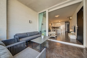 A modern living area with a sofa, a table, and a view into the kitchen. - St. Julian's Apartment 501 - Near Beach &Paceville (Saint Julian's)
