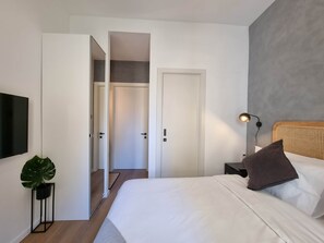 A bedroom with a bed, bedside table, lamp, and a plant. - St. Julian's Apartment 3Bed - Near Beach&Paceville (Saint Julian's)