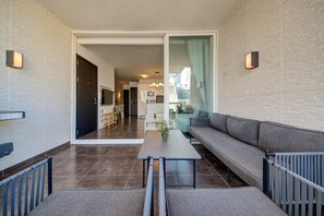 Uma sala moderna com um sofá, uma mesa e vista para a cozinha.