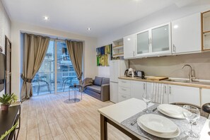 A modern apartment with a balcony, a dining area, and a kitchen with white cabinets. - St. Julian's Studio 201 - Near Beach & Paceville (Saint Julian's)
