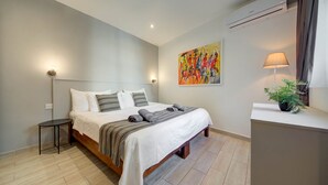 A bedroom with a bed, bedside table, lamp, and a painting on the wall. - St. Julian's Studio 204 - Near Beach & Paceville (Saint Julian's)