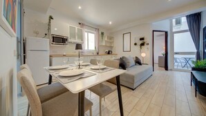 A modern kitchen with a dining area, a sofa, and a balcony with a view. - St. Julian's Studio 204 - Near Beach & Paceville (Saint Julian's)