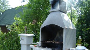 A stone-built outdoor oven with a chimney, surrounded by greenery. - In quiet Vrhpolje, cozy house with 3 bedrooms. With the best view in the region. (Vrhpolje)