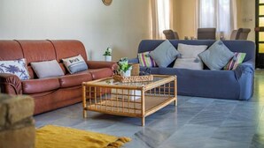 A living room with a brown leather sofa, a blue sofa, and a wooden coffee table. - Villa Anemone w/ private pool and jacuzzi in Polis (Polis Chrysochous)