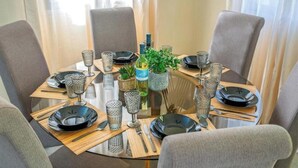 A dining table set for four with chairs, glassware, plates, and cutlery. - Villa Anemone w/ private pool and jacuzzi in Polis (Polis Chrysochous)