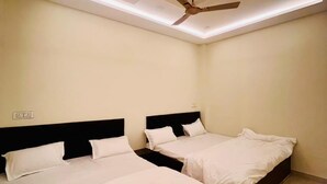 A hotel room with two beds, a ceiling fan, recessed lighting, and a tiled floor.