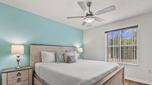 A bedroom with a bed, nightstands, a ceiling fan, and a window with a view. - Sleeps 6·BBQ·Game Table·Clubhouse Amenities (Kissimmee)
