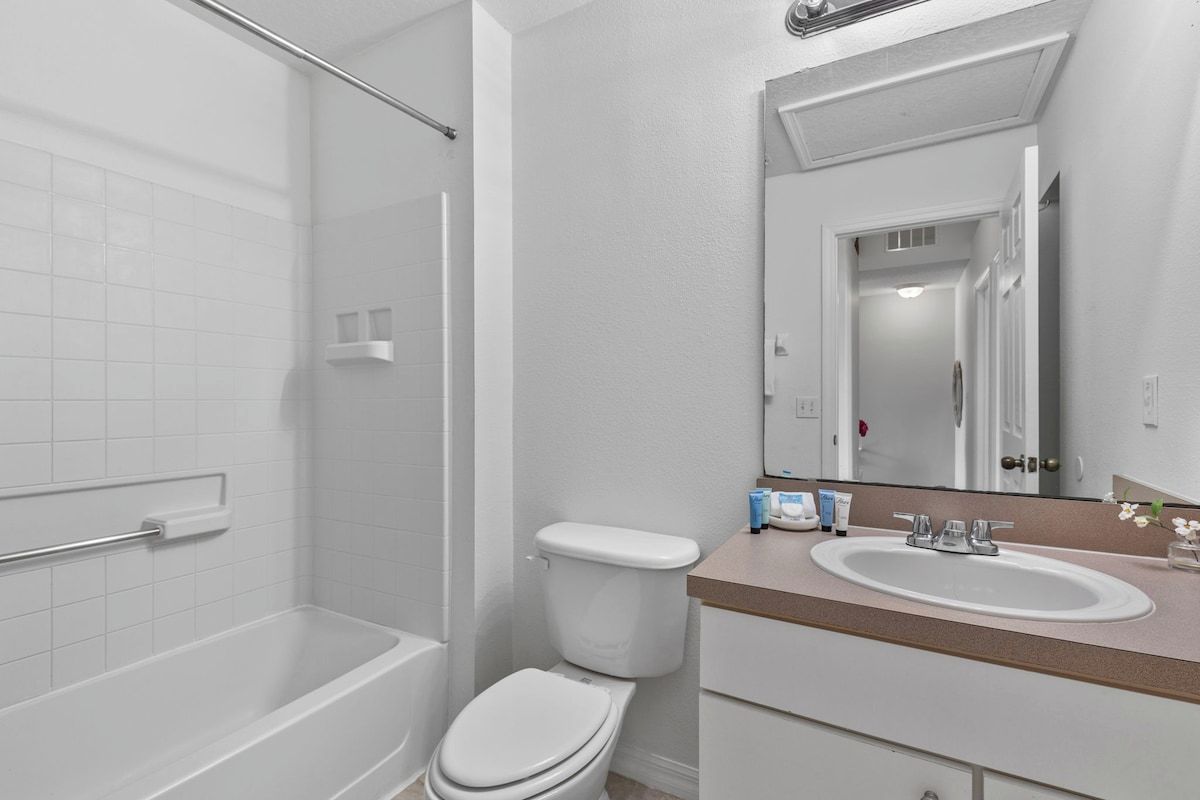 A bathroom with a bathtub, toilet, and sink.