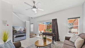 A living room with a sofa, coffee table, television, and a foosball table. - Sleeps 6·BBQ·Game Table·Clubhouse Amenities (Kissimmee)