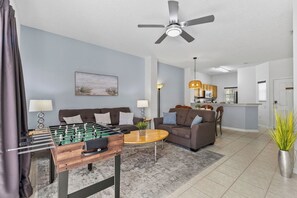 A living room with a foosball table, sofas, a coffee table, and a ceiling fan. - Sleeps 6·BBQ·Game Table·Clubhouse Amenities (Kissimmee)