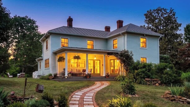 A two-story house with a covered porch, a stone pathway, and a well-maintained garden. - Blue Ridge Getaway (Roseland)