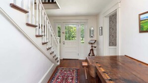 A hallway with a wooden bench, a patterned rug, and a white door with a window. - Blue Ridge Getaway (Roseland)