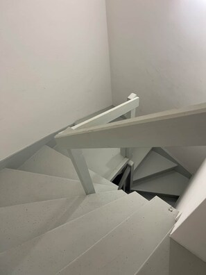 A staircase with white steps and metal railings.