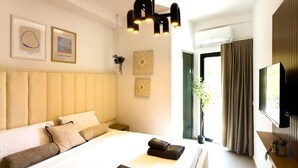 Una habitació d'hotel amb un llit gran, televisió i obra d'art a la paret.