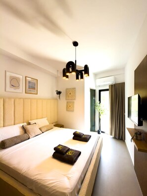 Ein Hotelzimmer mit einem großen Bett, einem Fernseher und Kunstwerken an der Wand.