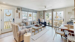 Uma sala de estar ampla com sofá, mesa de centro e área de refeições.