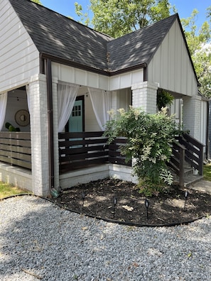 Ein Haus mit Veranda, Treppe und Garten.