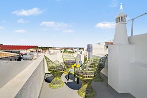 A rooftop terrace with outdoor seating, a white tower, and a view of the cityscape. - Holiday Home 'A Casa Da Velha' with Private Terrace, Wi-Fi and Air Conditioning (Alvor)
