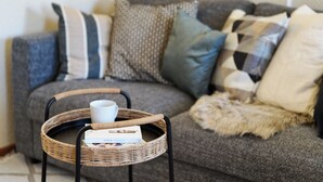 A living room with a grey sofa, a wicker coffee table, and a white mug. - Spacious Central Apartment for 6 Guests in the Heart of Trier (Trier)