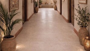 Un pasillo con techo de madera, arcos y plantas en macetas.